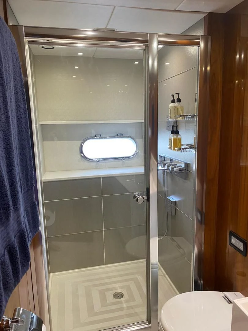 a bathroom with a glass shower aboard RIII Yacht for Sale