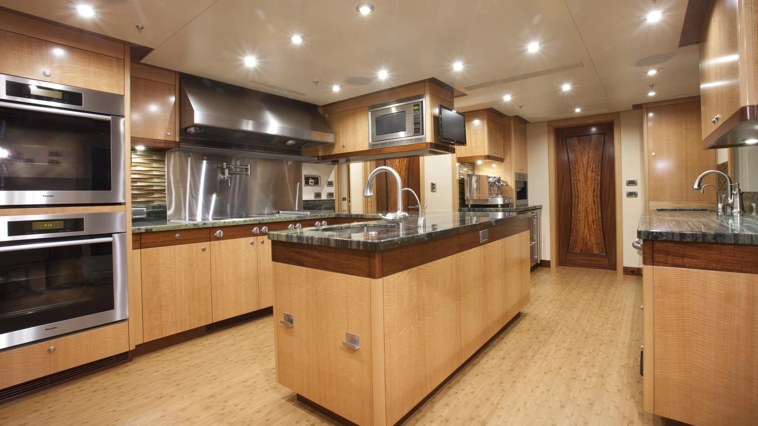 a kitchen with wooden cabinets aboard CHIRON Yacht for Sale