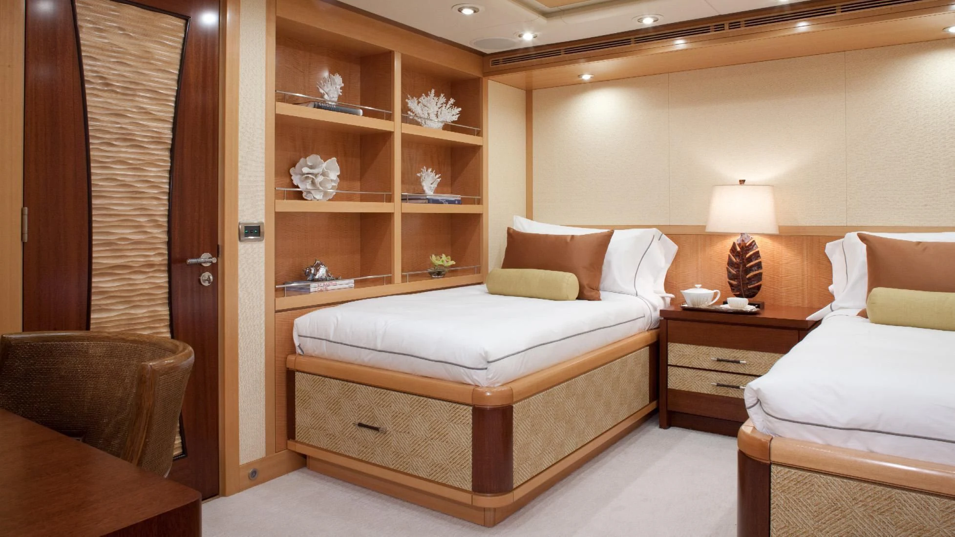 a room with a bed and a shelf with a lamp aboard CHIRON Yacht for Sale