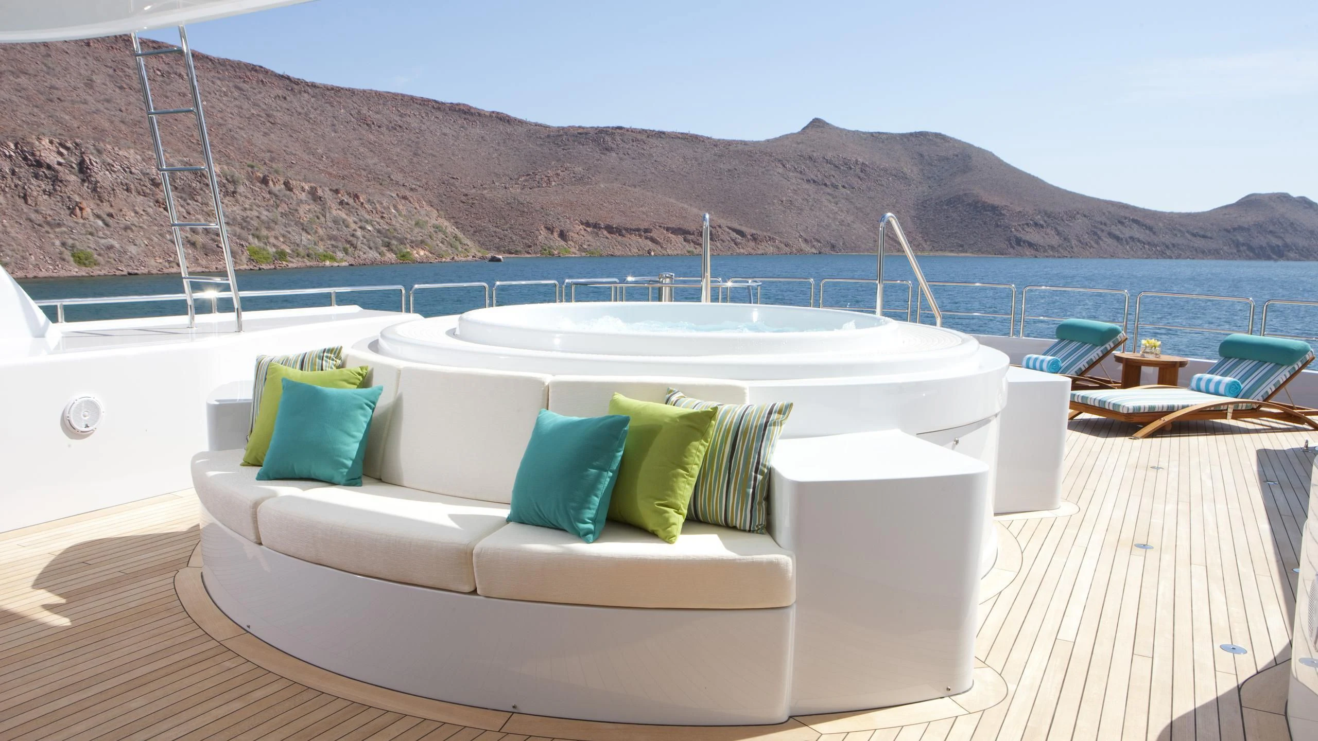 a white couch on a deck overlooking a large body of water aboard CHIRON Yacht for Sale