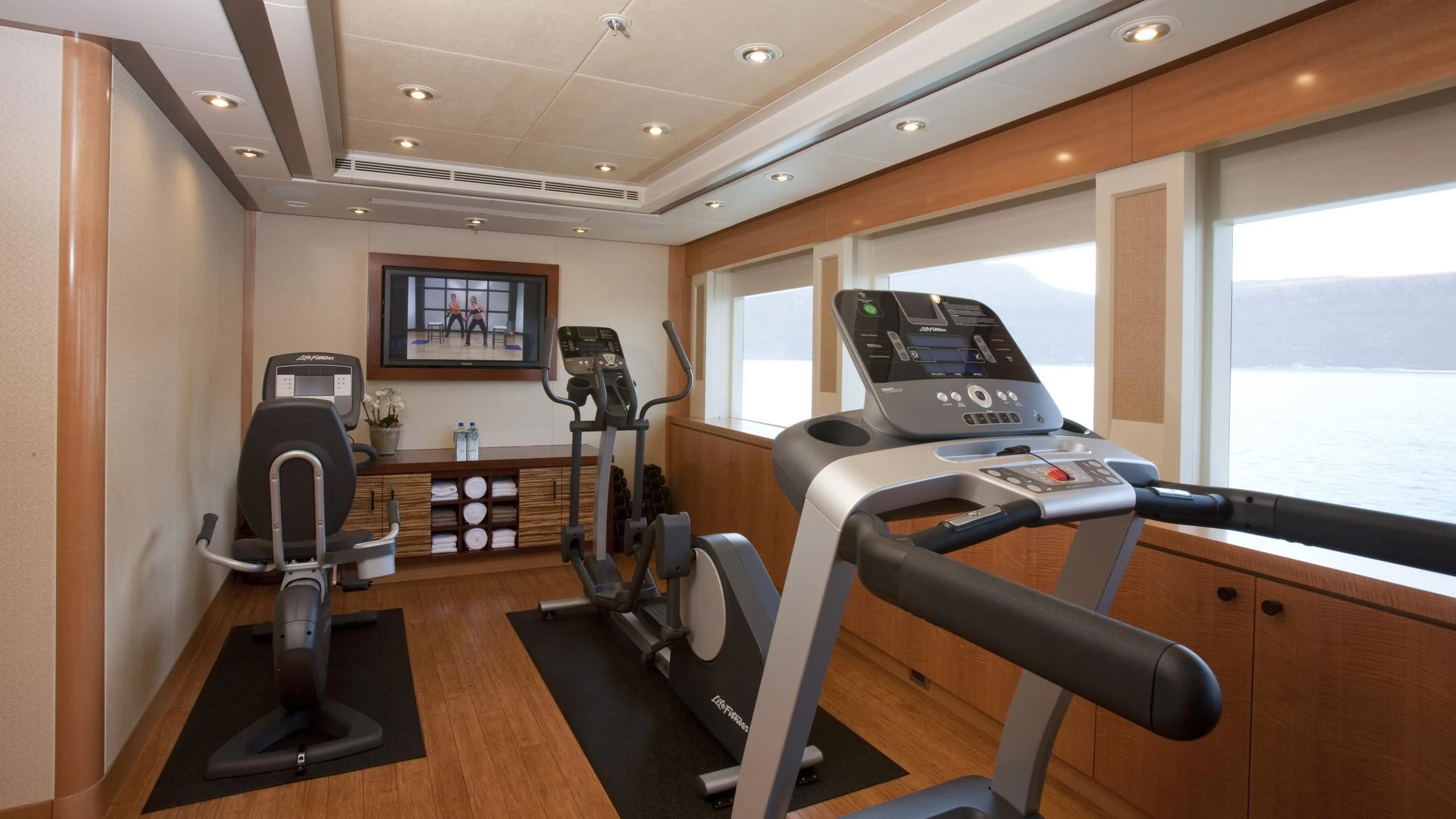 a room with treadmills and a window aboard CHIRON Yacht for Sale