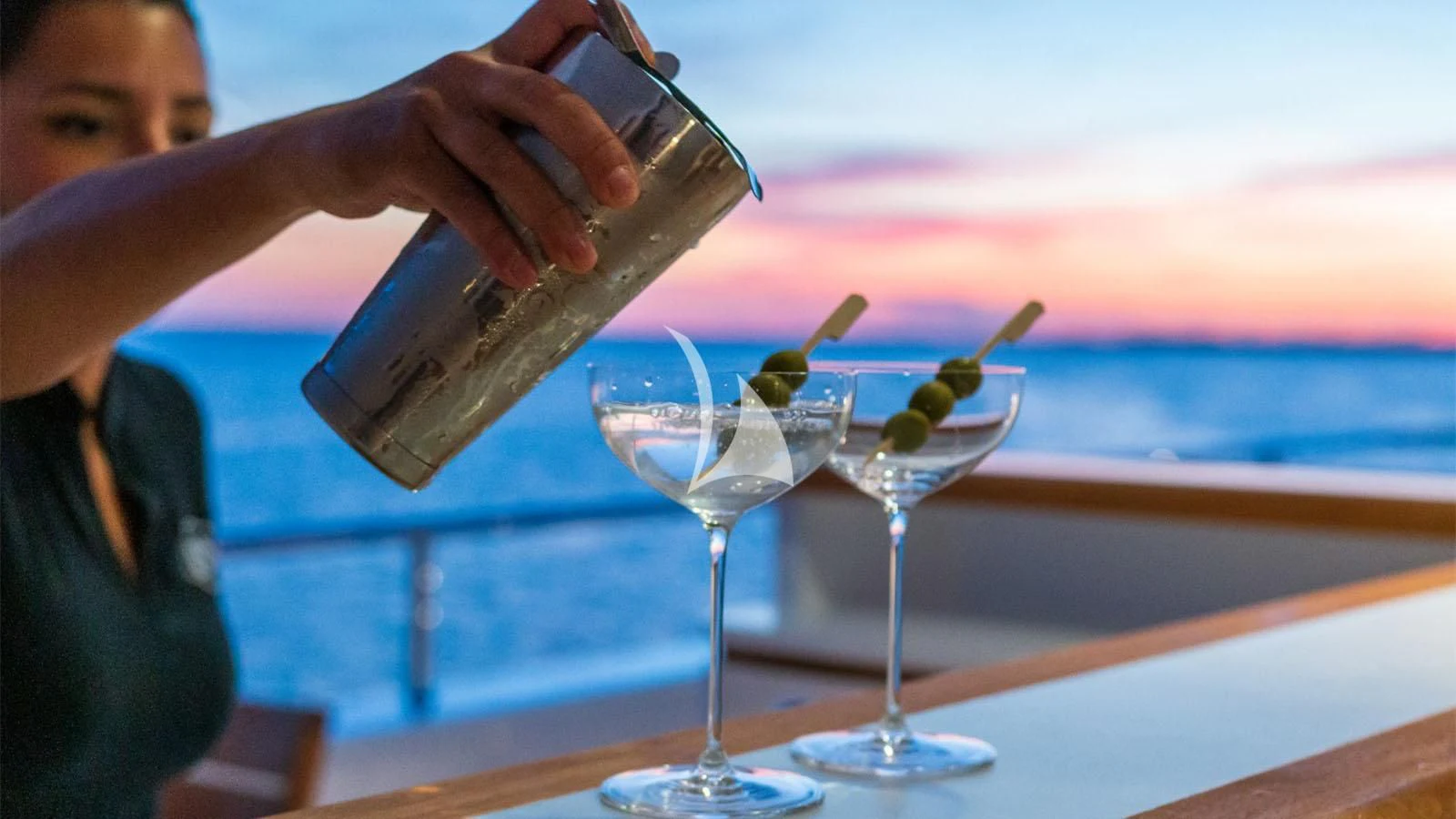 a person pouring a drink into a glass aboard BON VIVANT Yacht for Sale