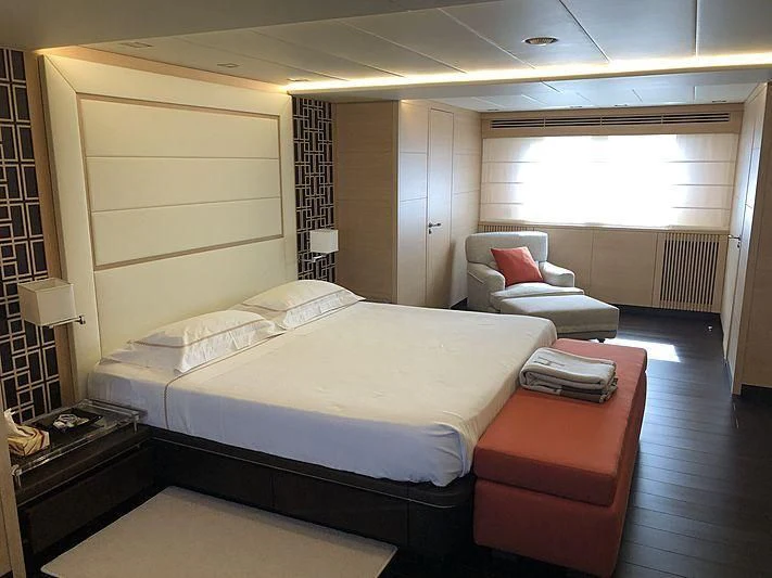 a bedroom with a bed and a chair aboard BON VIVANT Yacht for Sale