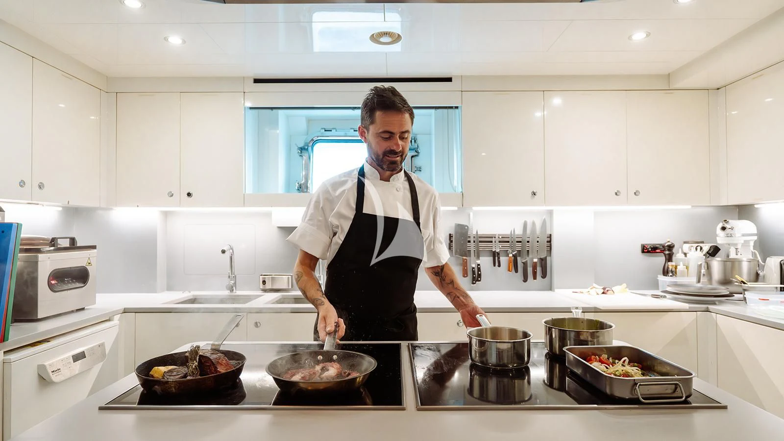 a person cooking in a kitchen aboard BON VIVANT Yacht for Sale
