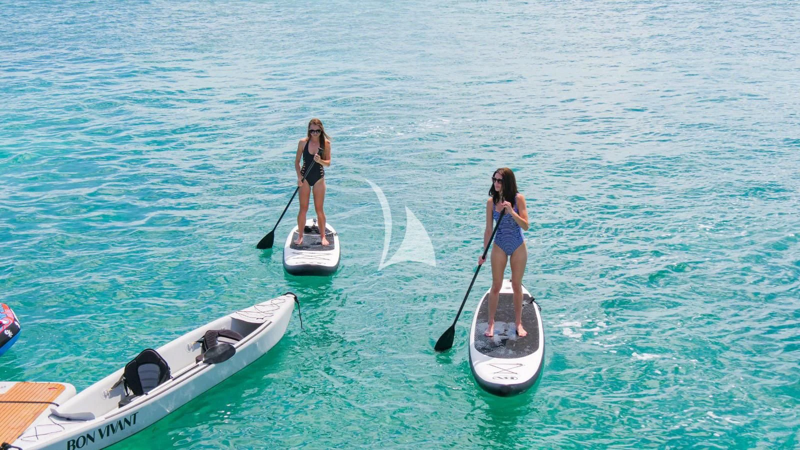 a couple of women on paddle boats in the water aboard BON VIVANT Yacht for Sale