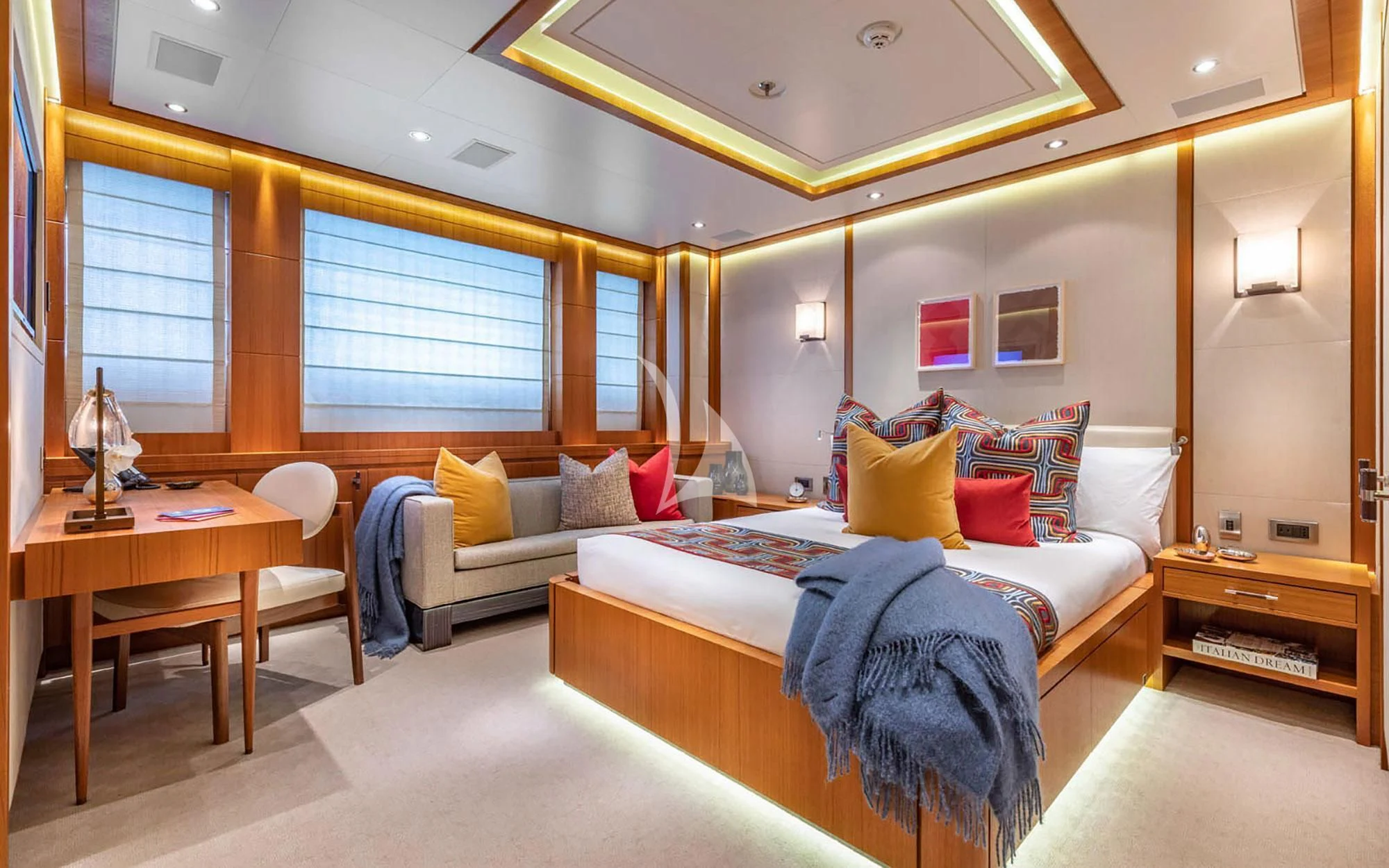 a bedroom with a bed and a desk aboard MAN OF STEEL Yacht for Charter