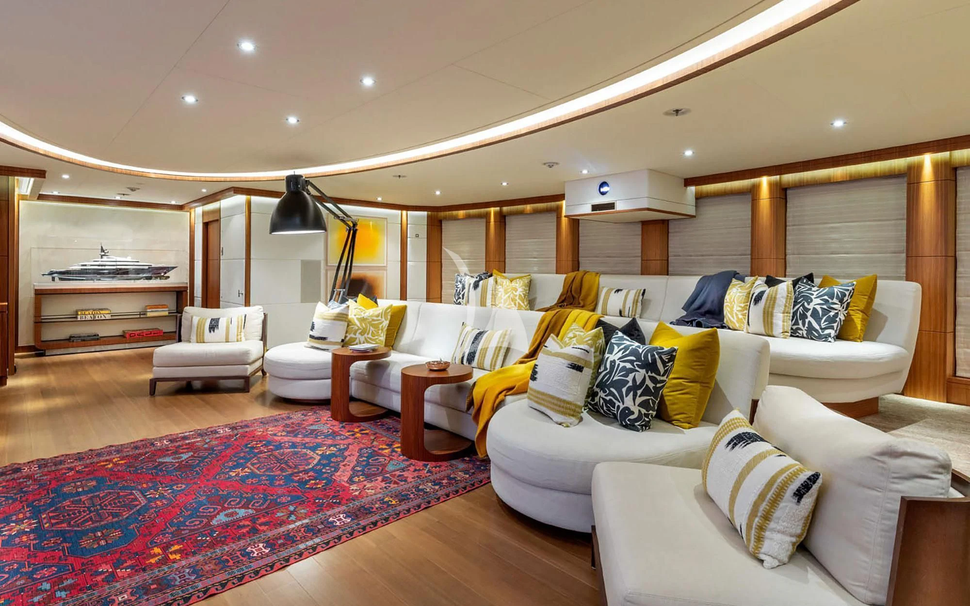 a large living room with a colorful rug aboard MAN OF STEEL Yacht for Charter