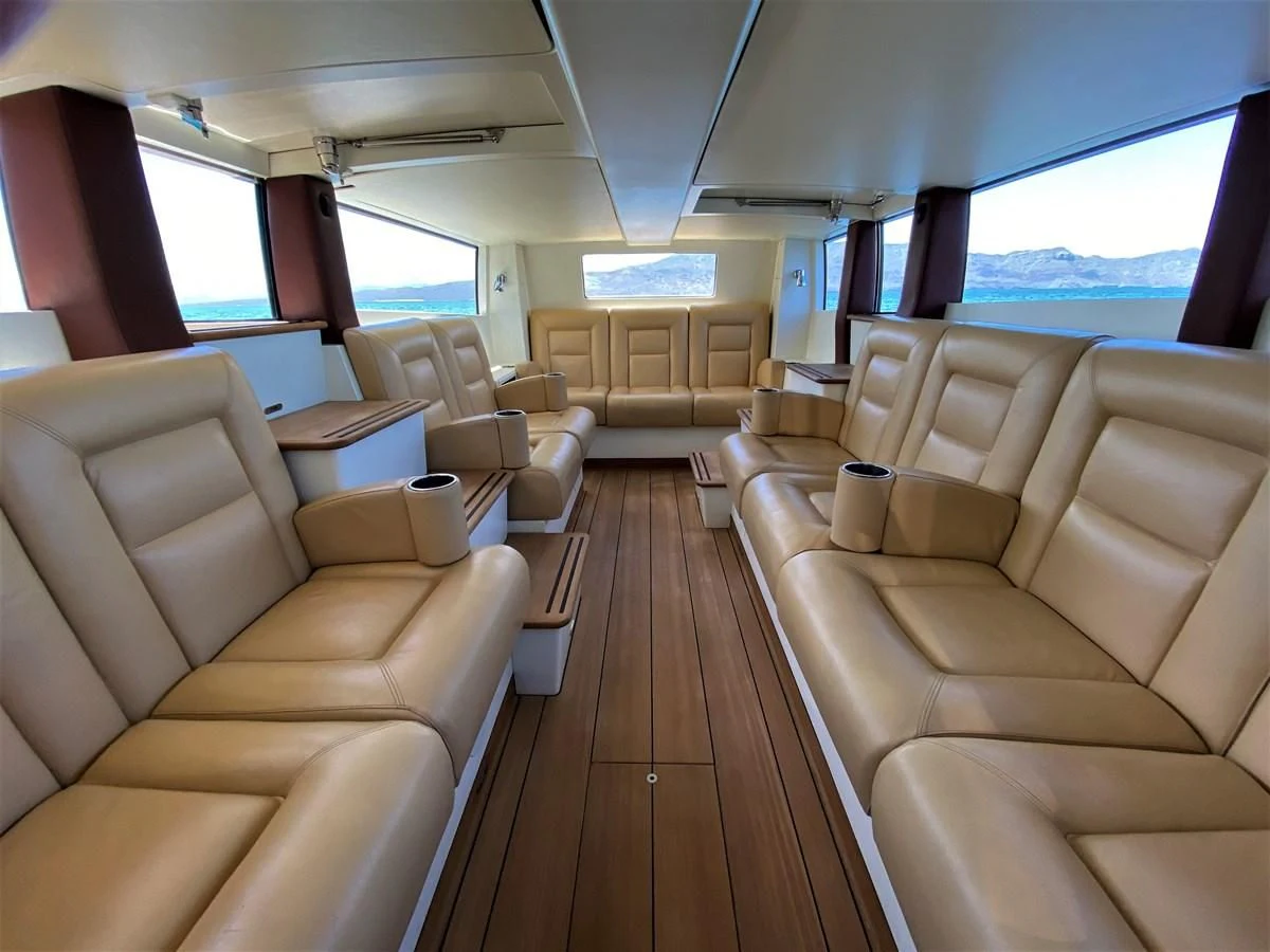 a room with a wood floor and a large window with chairs and a wood floor aboard MAN OF STEEL Yacht for Charter