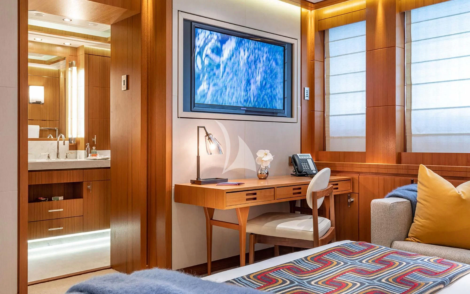 a room with a bed and a desk aboard MAN OF STEEL Yacht for Charter