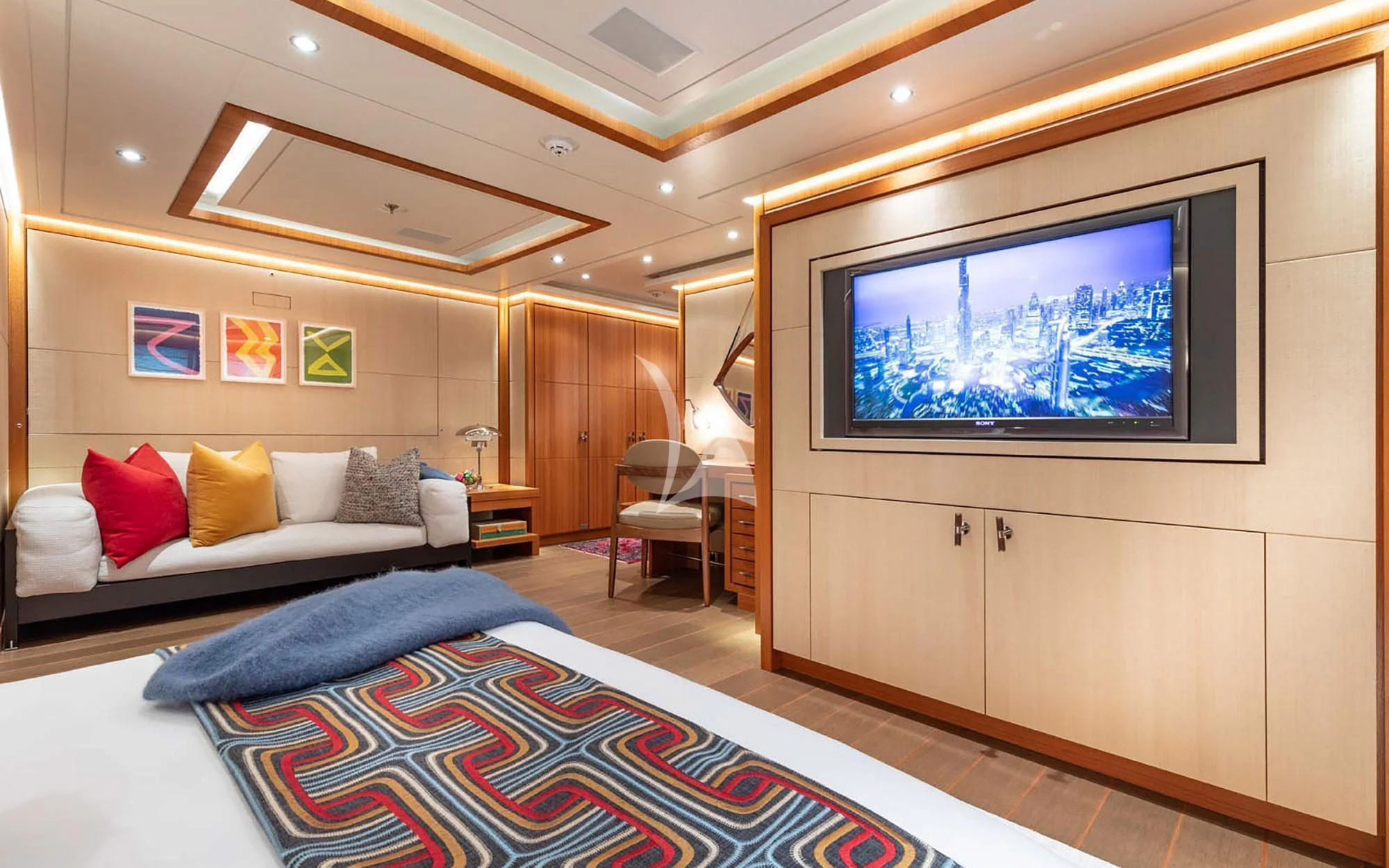 a room with a bed and a tv aboard MAN OF STEEL Yacht for Charter
