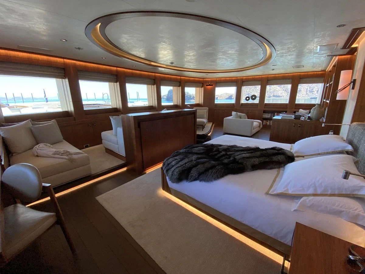 a room with a bed and a couch aboard MAN OF STEEL Yacht for Charter