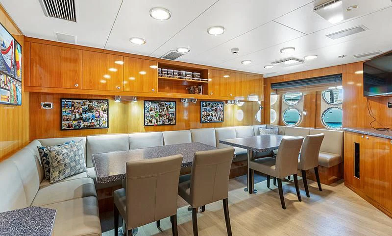 a room with tables and chairs aboard AHS Yacht for Sale