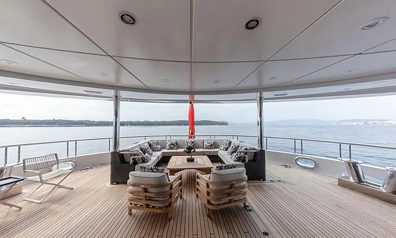 a room with a table and chairs on a deck aboard AHS Yacht for Sale