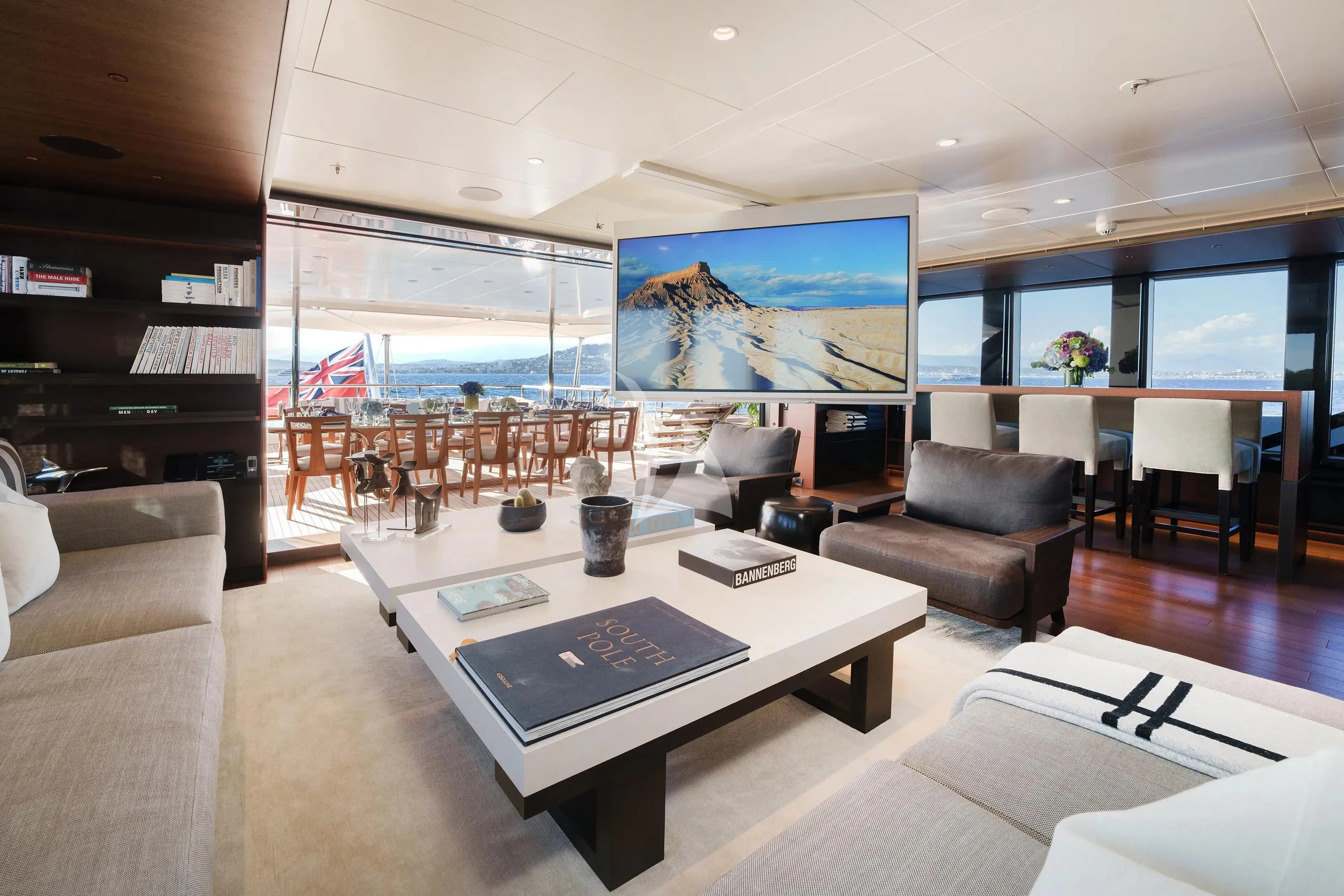 a room with a table chairs and a tv aboard HALO Yacht for Charter