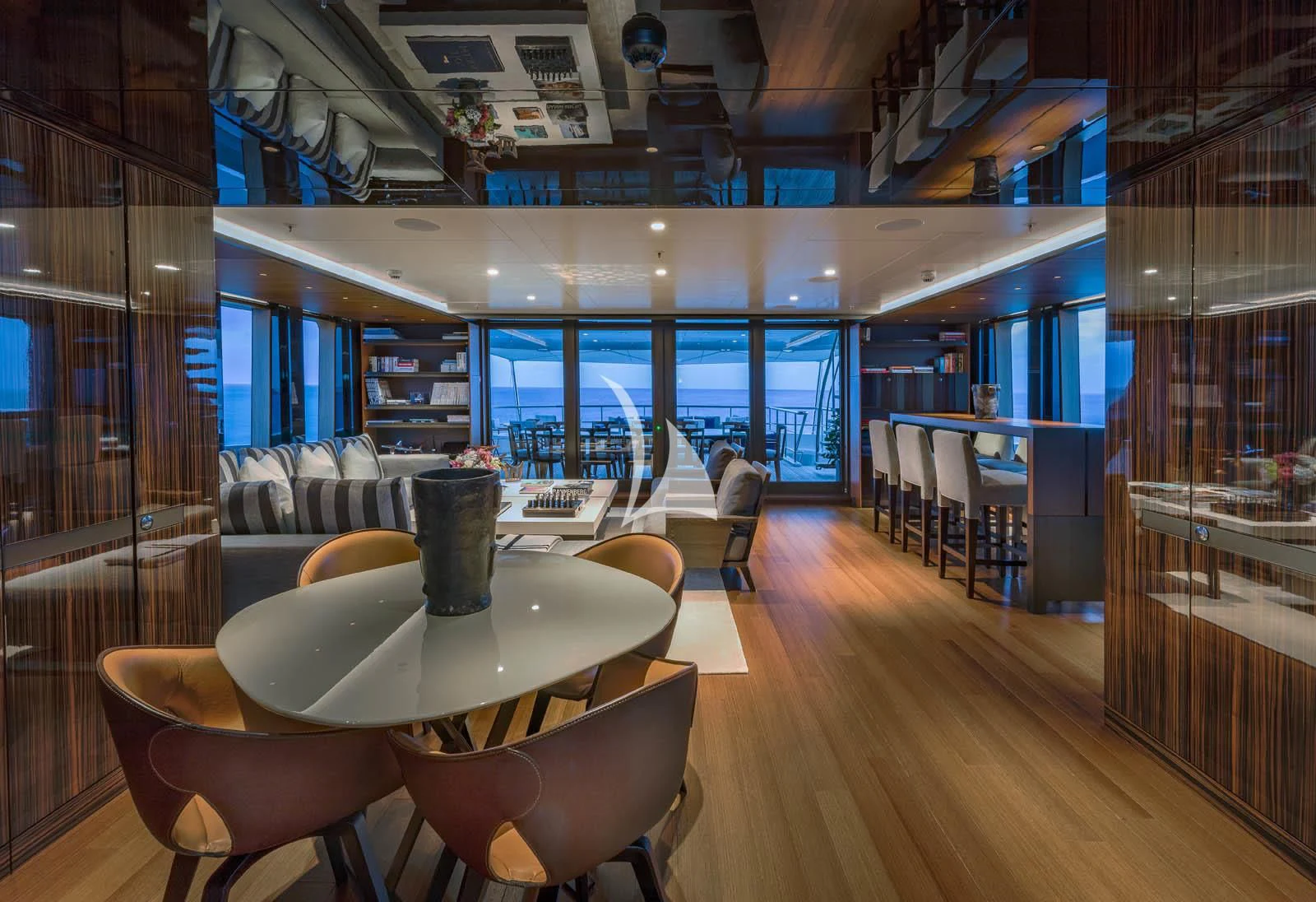 a room with a wood floor and chairs and a wood floor aboard HALO Yacht for Charter