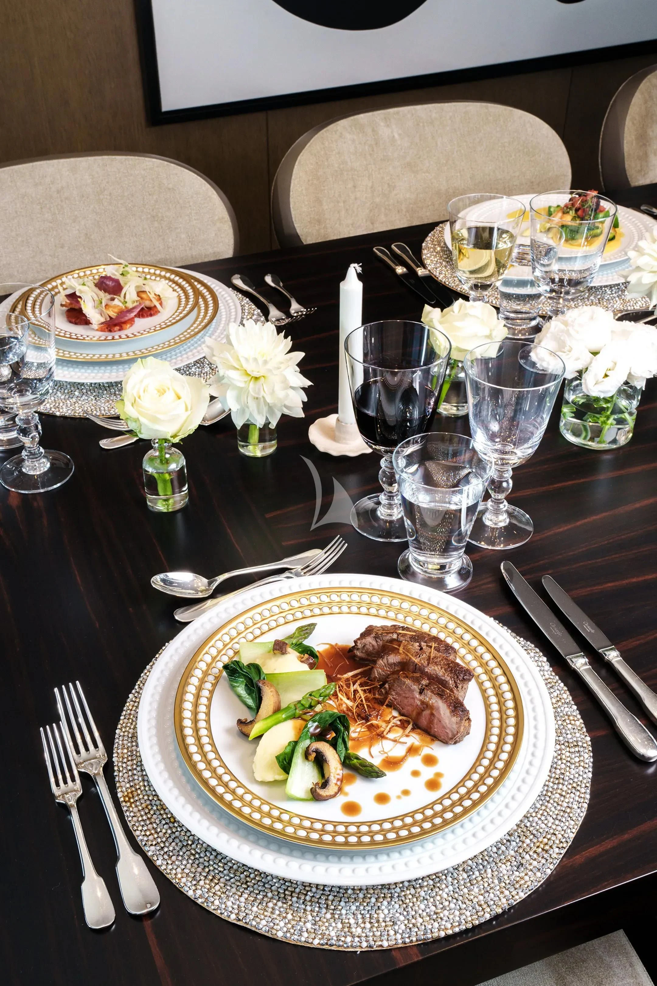 a table with plates and glasses of food on it aboard HALO Yacht for Charter