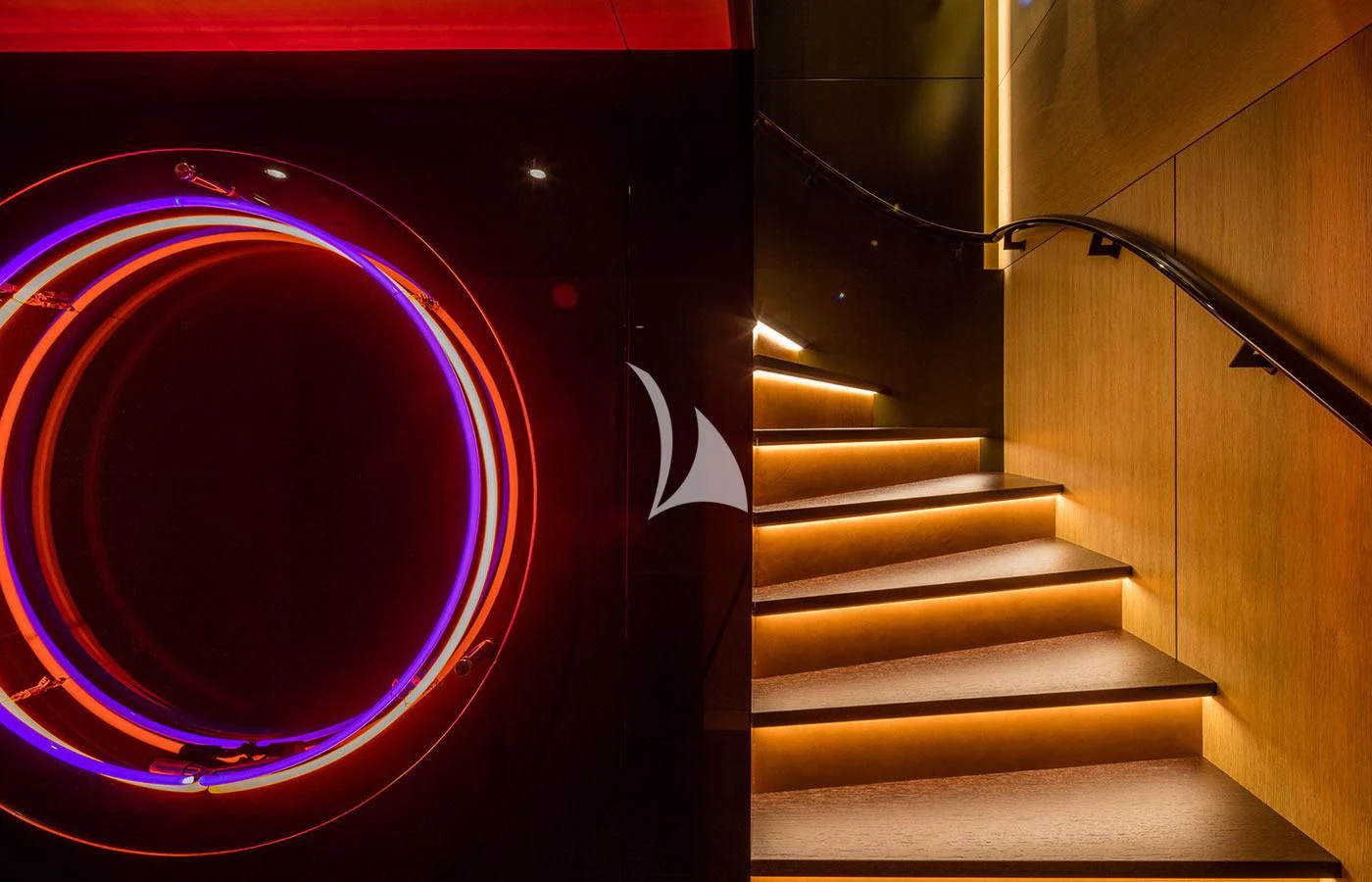 a staircase leading to a red lit up stage aboard HALO Yacht for Charter