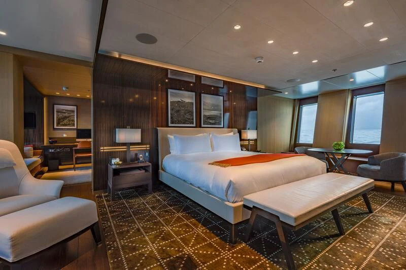 a large hotel room with a large bed and a table aboard HALO Yacht for Charter