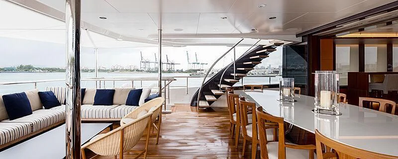 a large room with a table and chairs and a staircase aboard HALO Yacht for Charter