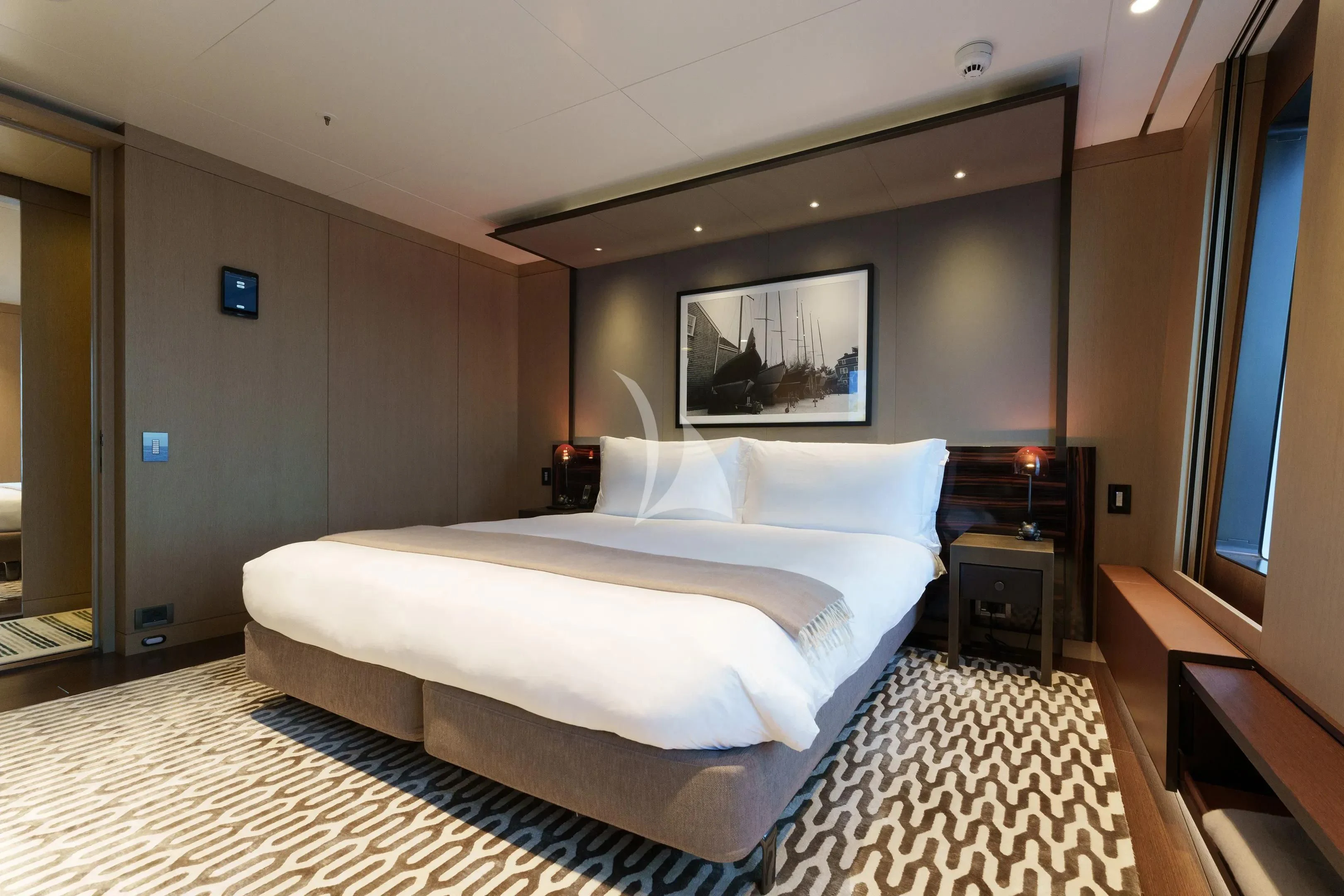 a bedroom with a bed and a tv on the wall aboard HALO Yacht for Charter