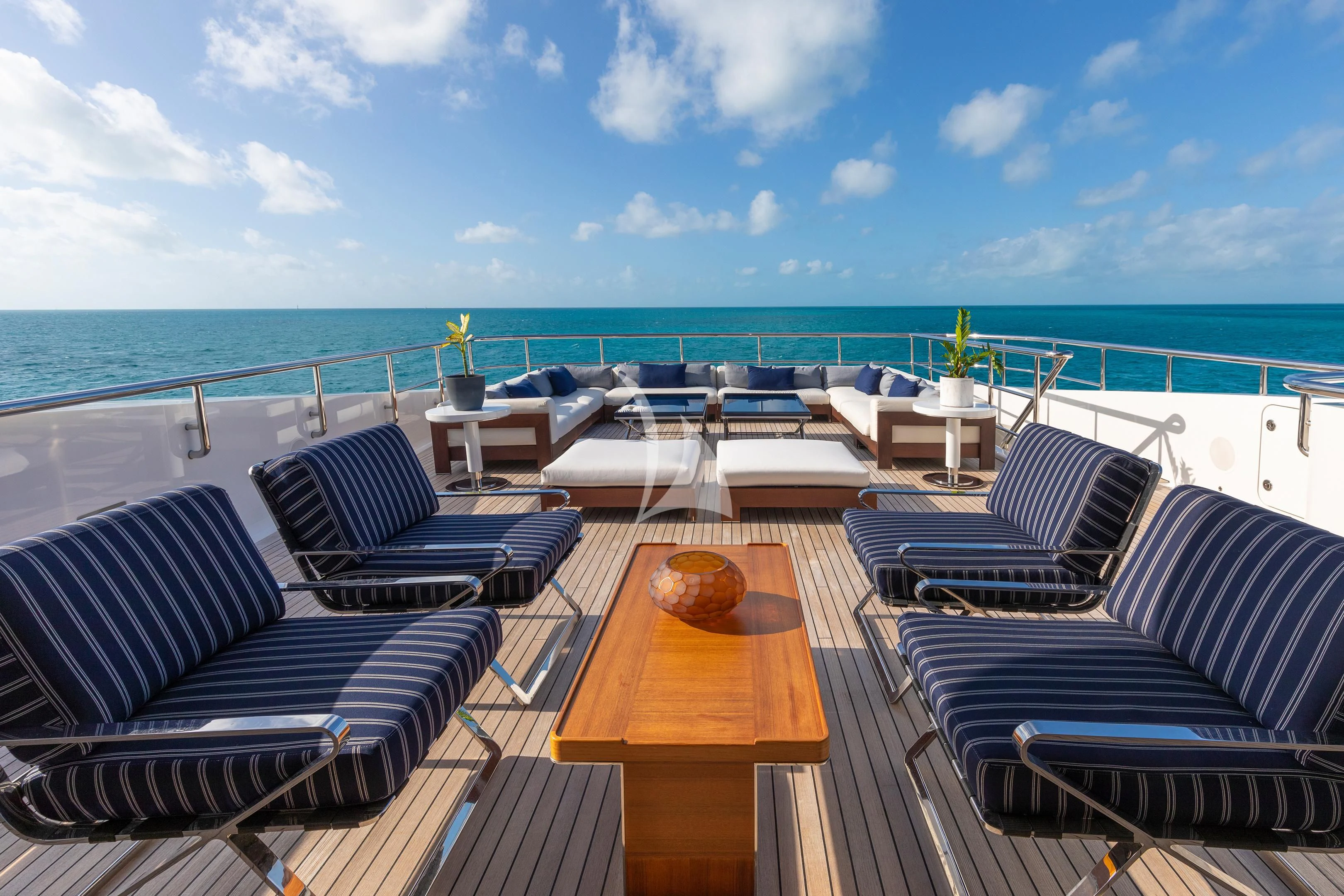 a deck with chairs and tables on it by the water aboard HALO Yacht for Charter