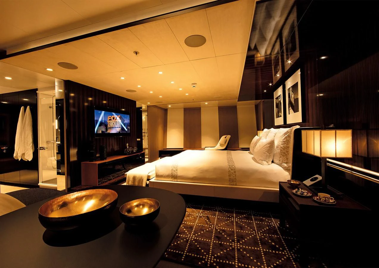 a hotel room with a bed and television aboard HALO Yacht for Charter