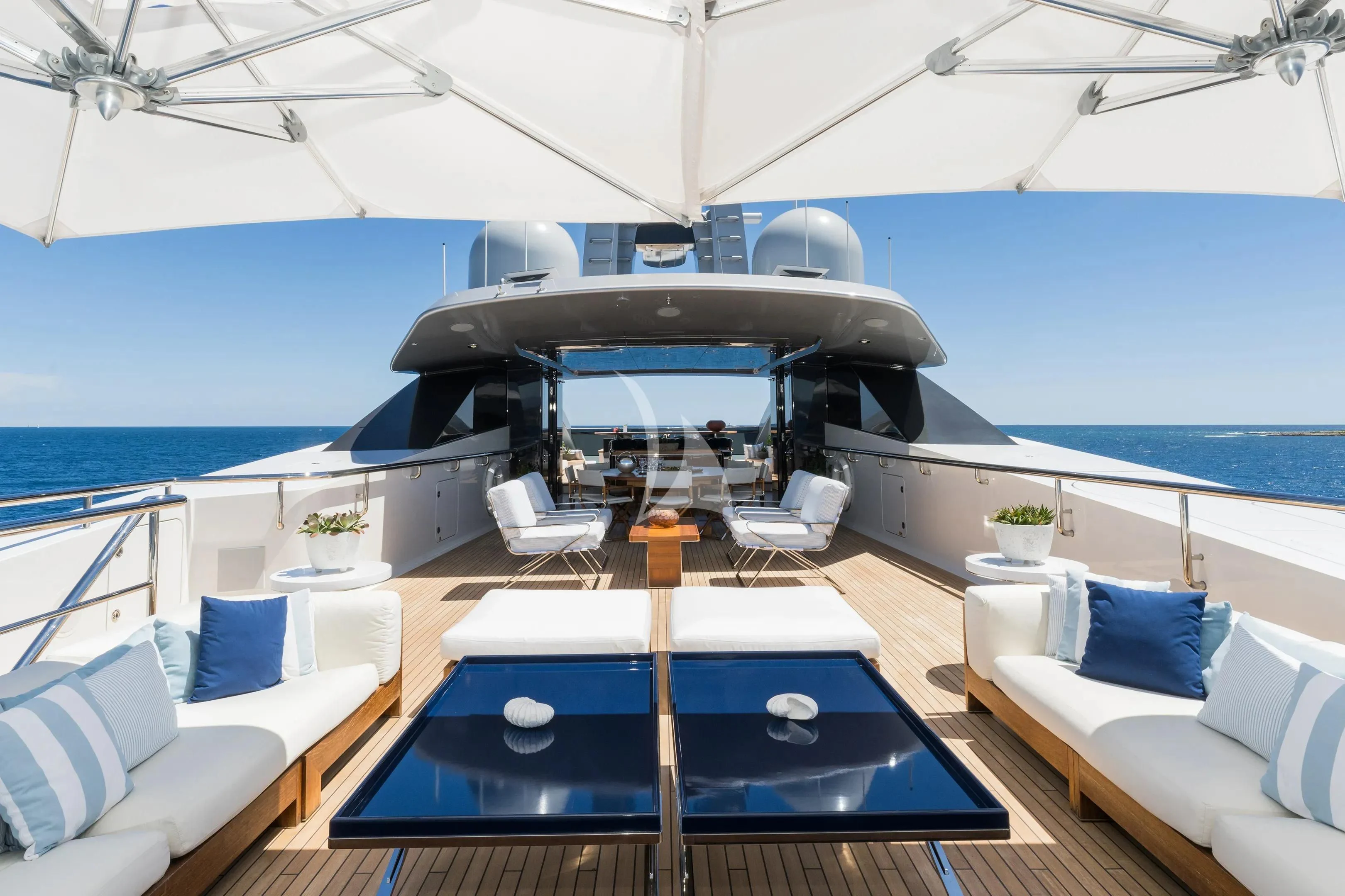 a large lounge area with a table and chairs on it aboard HALO Yacht for Charter