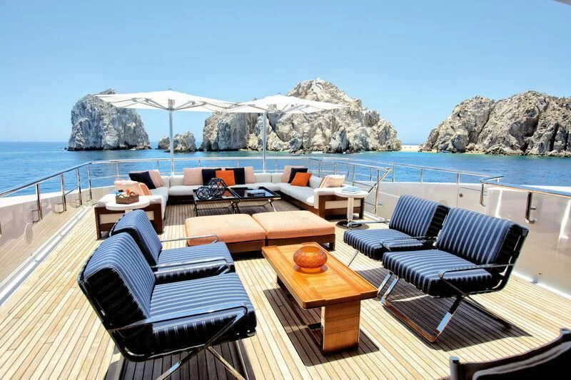 a deck with chairs and a table on it aboard HALO Yacht for Charter