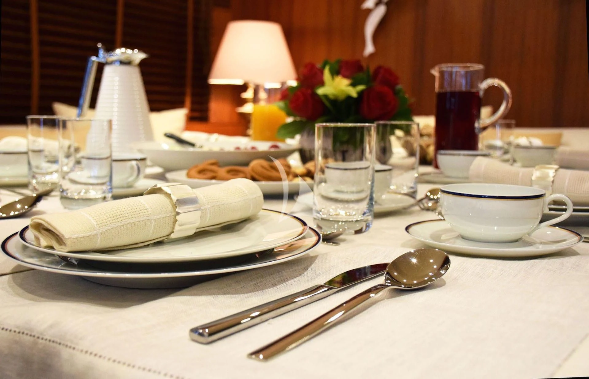 a table with a plate of food and glasses on it aboard OCEANE II Yacht for Sale