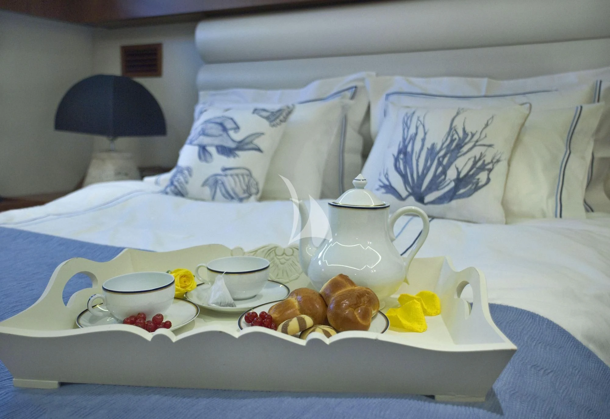 a tray of food and cups on a bed aboard OCEANE II Yacht for Sale