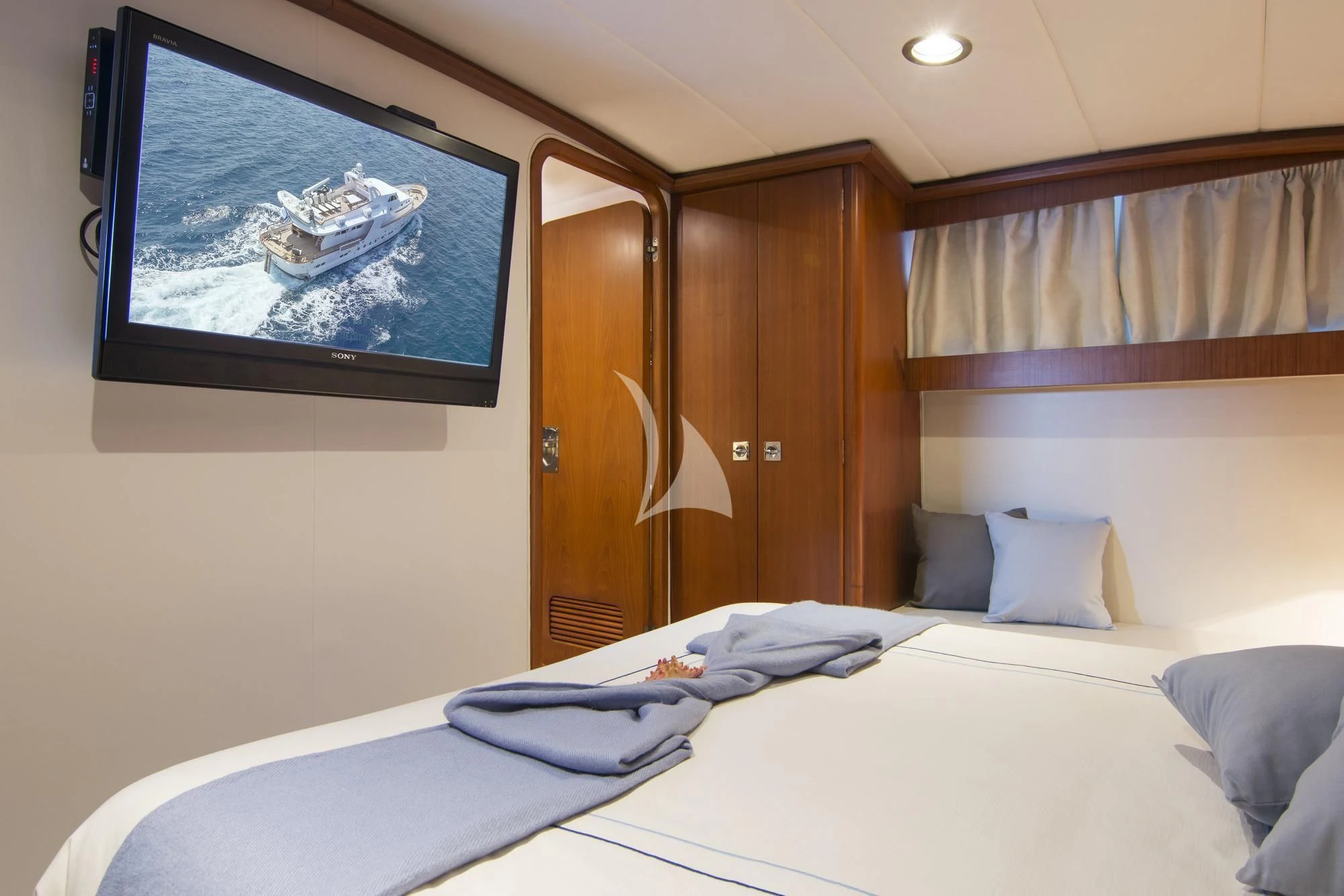 a bed with a white bed spread aboard OCEANE II Yacht for Sale