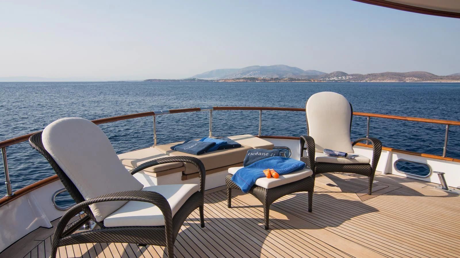 a table and chairs on a deck overlooking a large body of water aboard OCEANE II Yacht for Sale