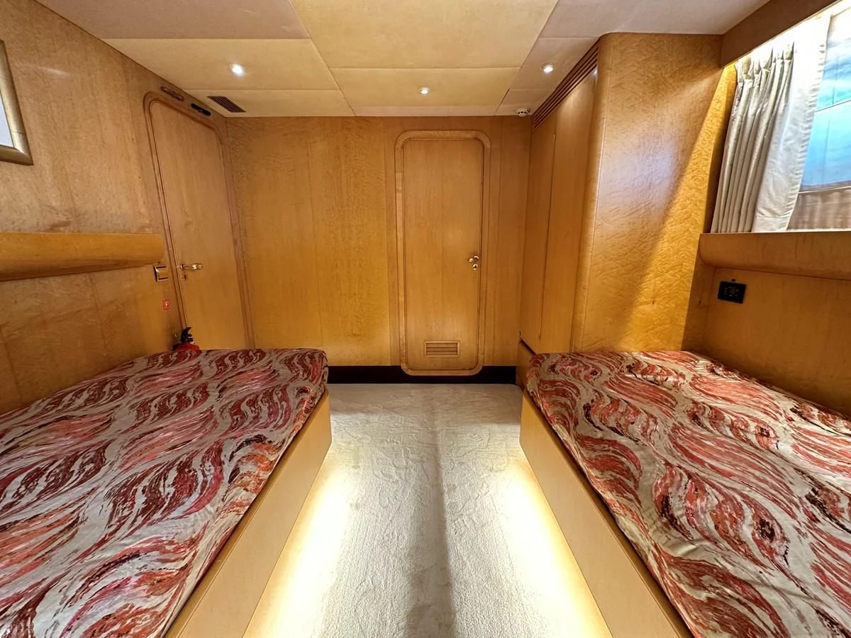 a room with beds and a window aboard CHEETAH MOON Yacht for Sale