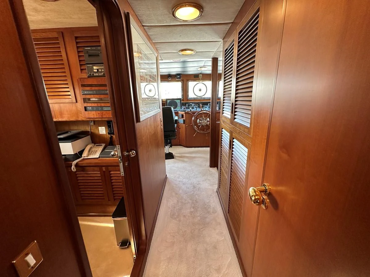 a hallway with a door and a clock on the wall aboard CHEETAH MOON Yacht for Sale