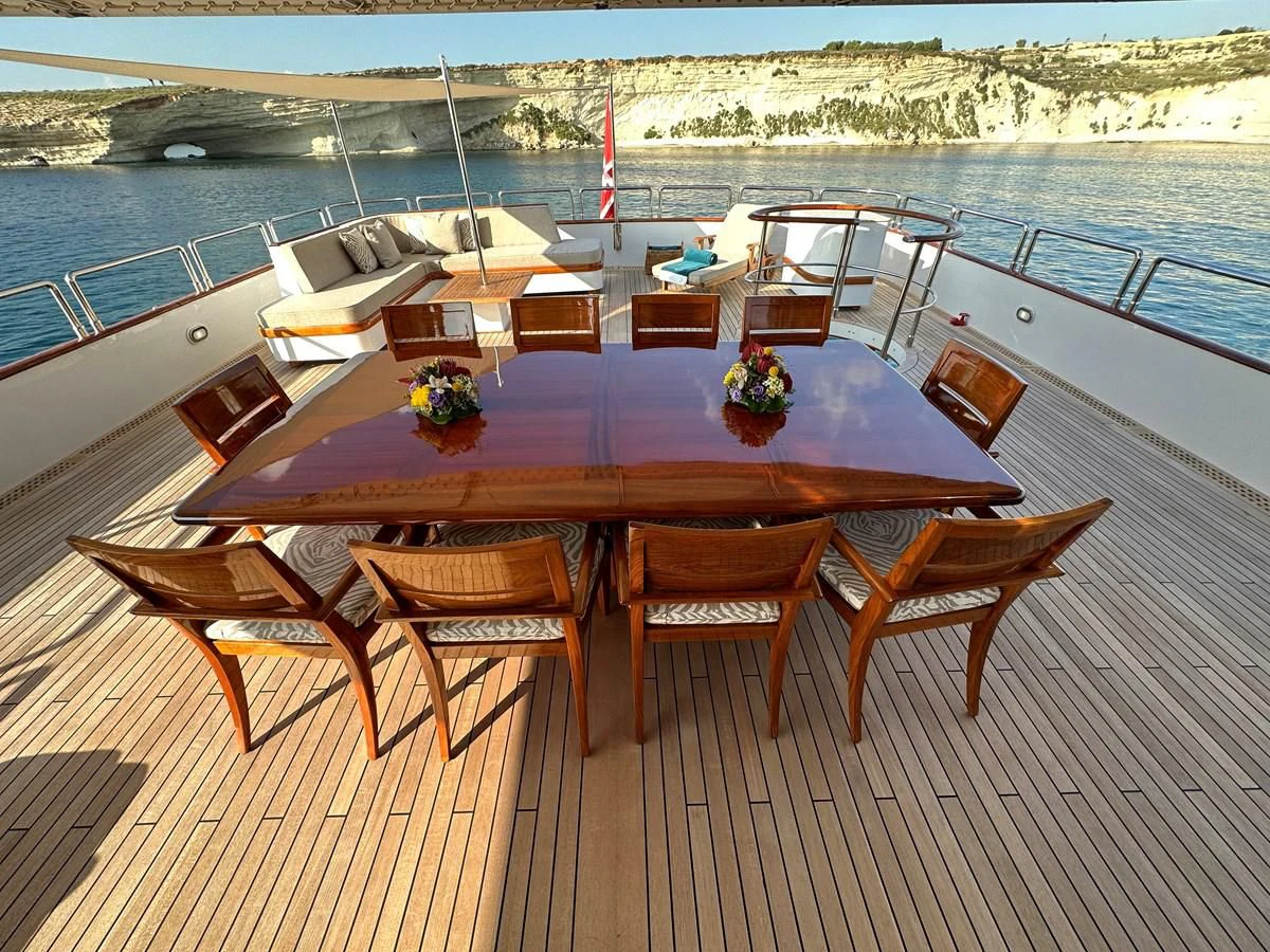 a table set on a deck overlooking a large body of water aboard CHEETAH MOON Yacht for Sale