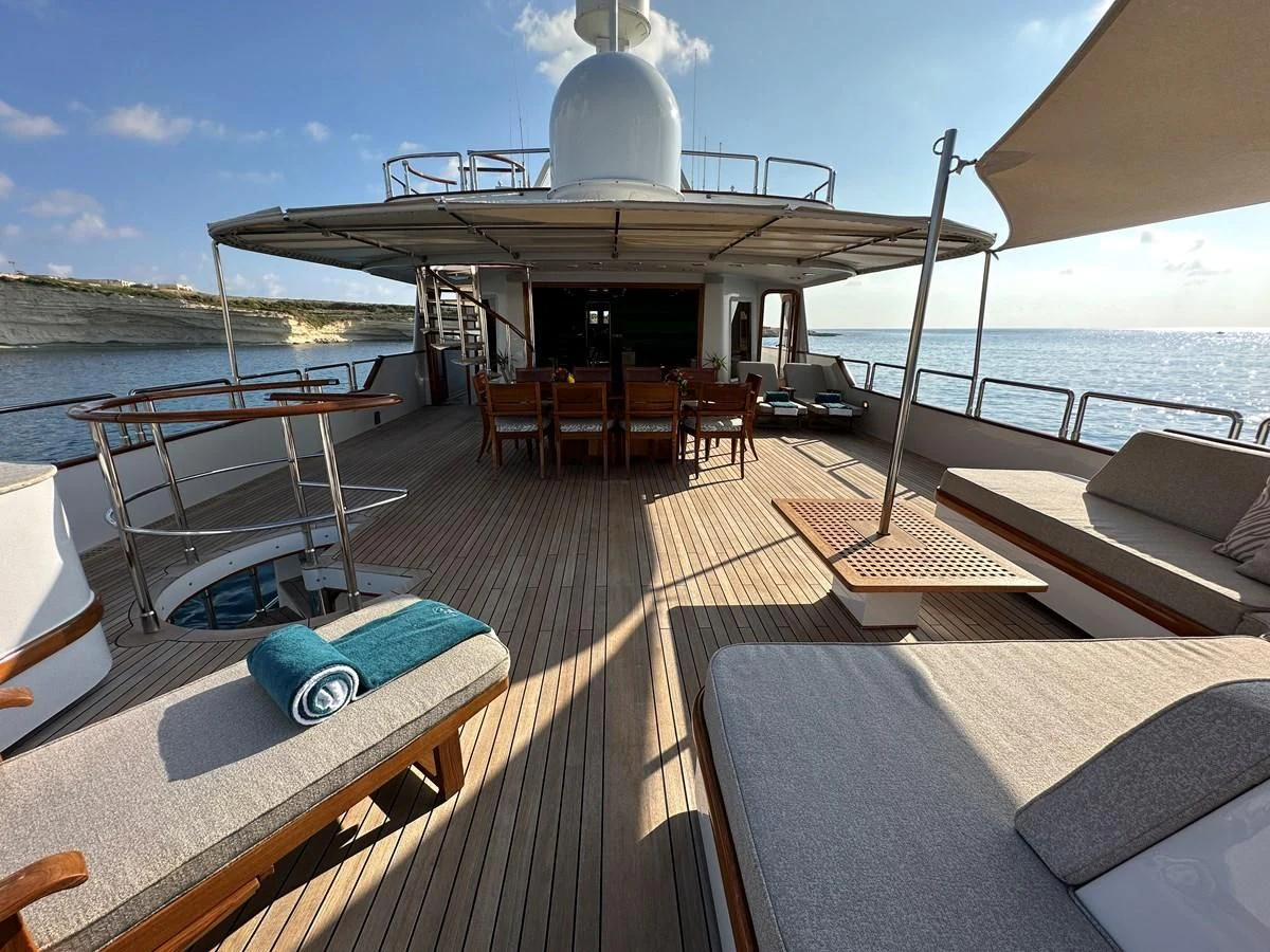 a deck with a pool and a boat on it aboard CHEETAH MOON Yacht for Sale