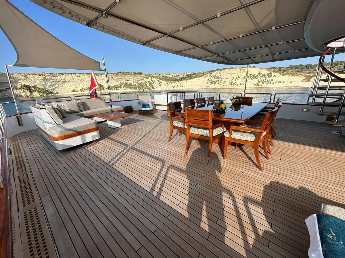 a deck with a table and chairs on it aboard CHEETAH MOON Yacht for Sale