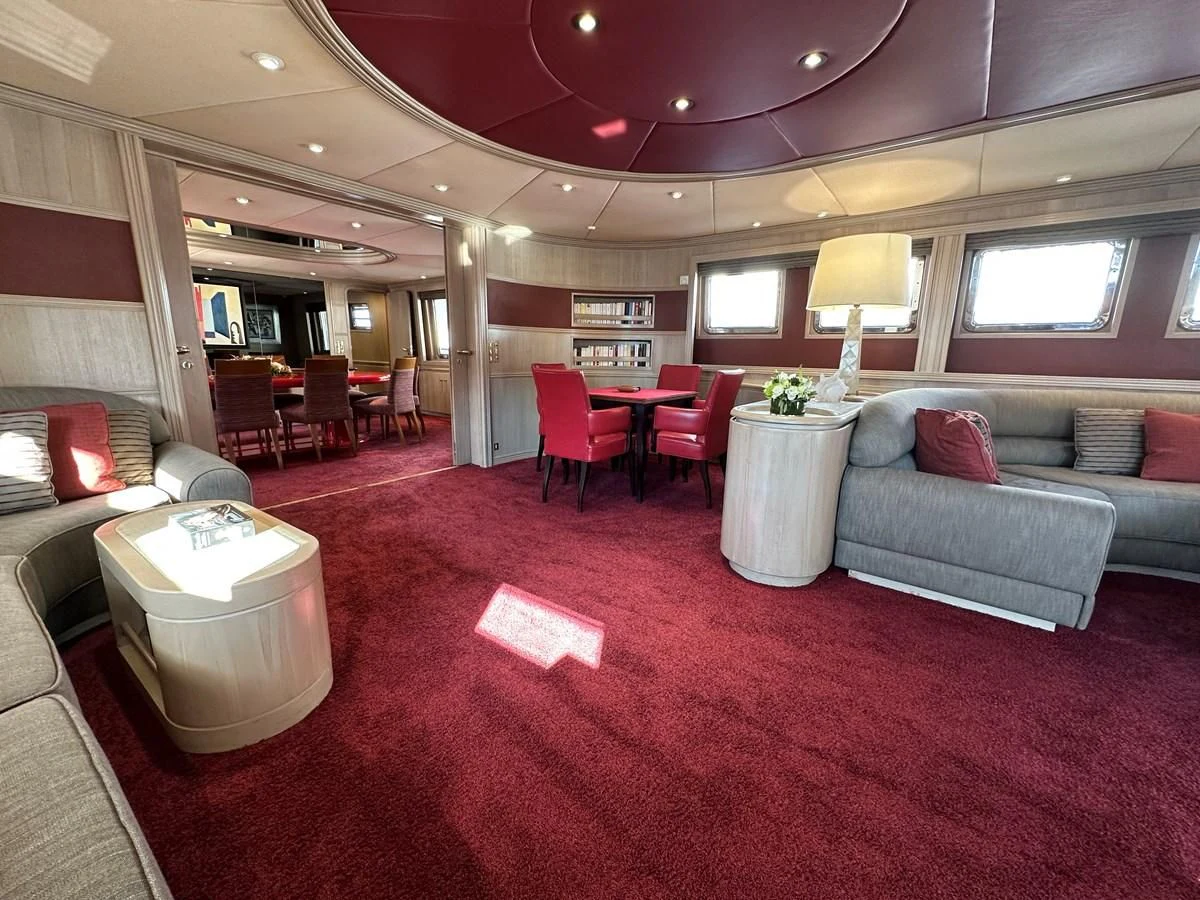 a living room with red carpet aboard CHEETAH MOON Yacht for Sale
