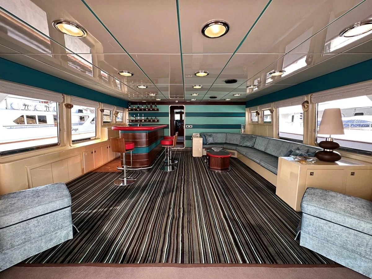 a room with a couch and a table and a chair aboard CHEETAH MOON Yacht for Sale