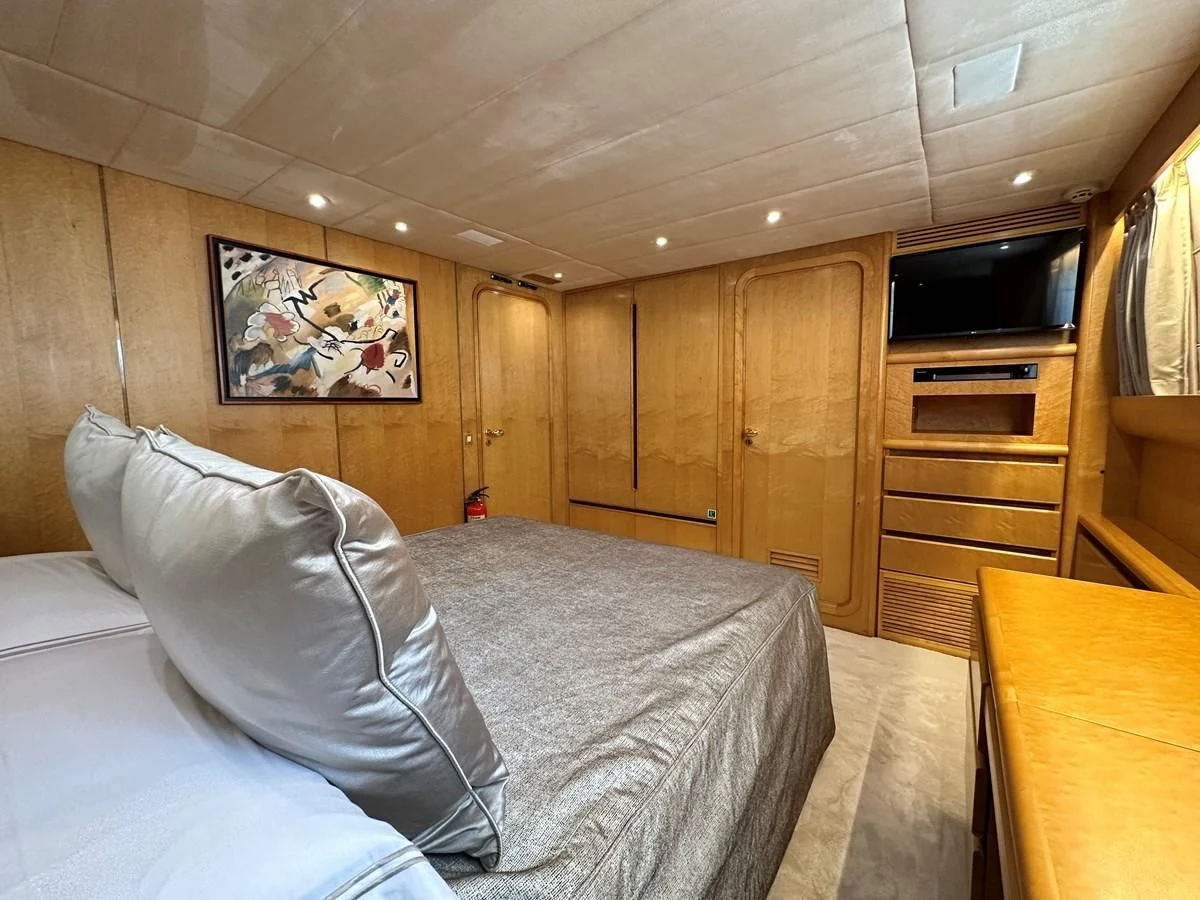 a bedroom with a bed and a television aboard CHEETAH MOON Yacht for Sale