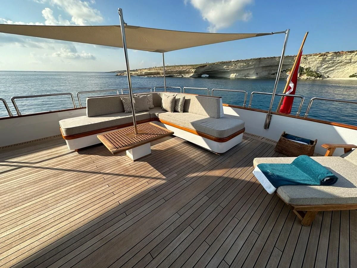 a deck with a chair and a boat on it aboard CHEETAH MOON Yacht for Sale