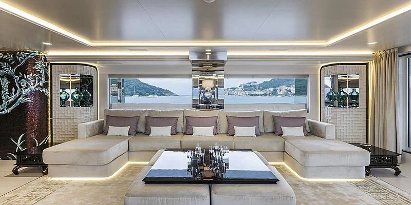 a large living room with a large sofa and a large window aboard PARILLION Yacht for Sale