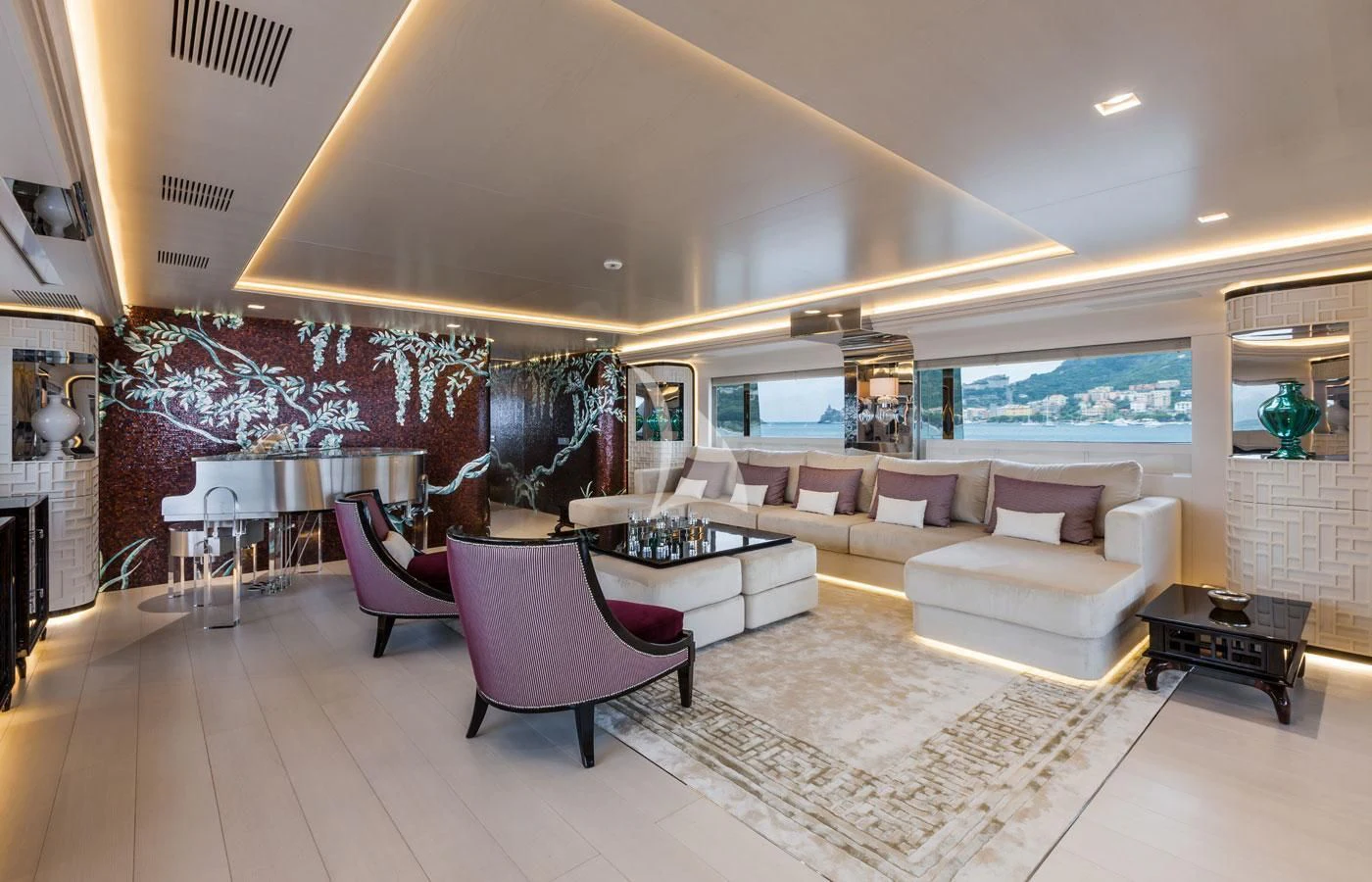 a living room with a large white sofa and a large window aboard PARILLION Yacht for Sale