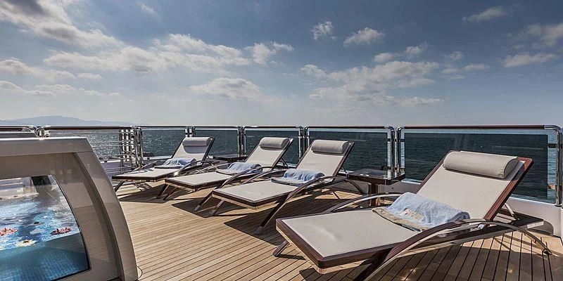 a deck with a view of the ocean and boats on it aboard PARILLION Yacht for Sale
