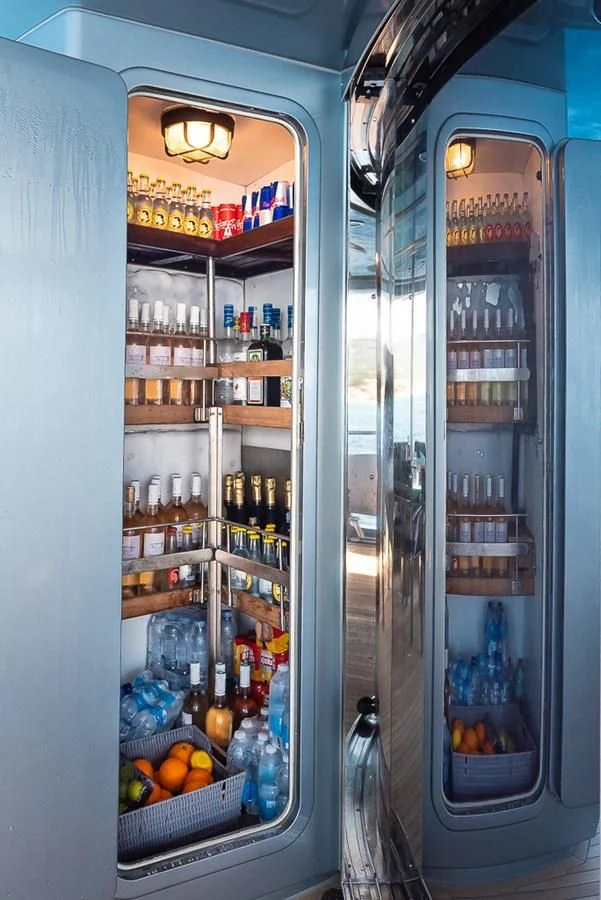 a refrigerator with a lot of bottles and cans of water aboard SMOOTH OPERATOR Yacht for Sale