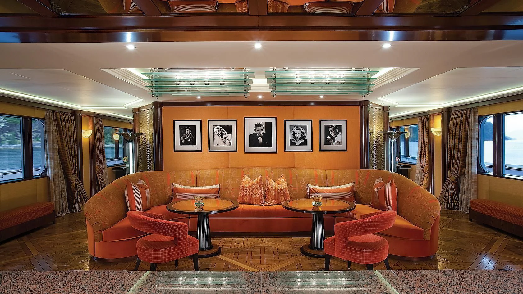 a living room with orange couches aboard ATTESSA IV Yacht for Sale