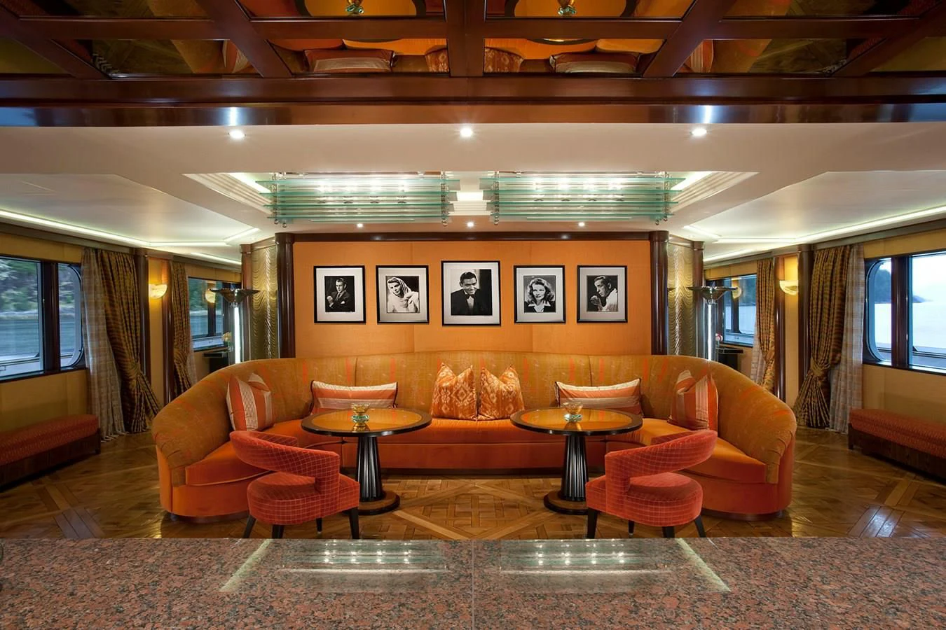 a room with orange couches and a table aboard ATTESSA IV Yacht for Sale