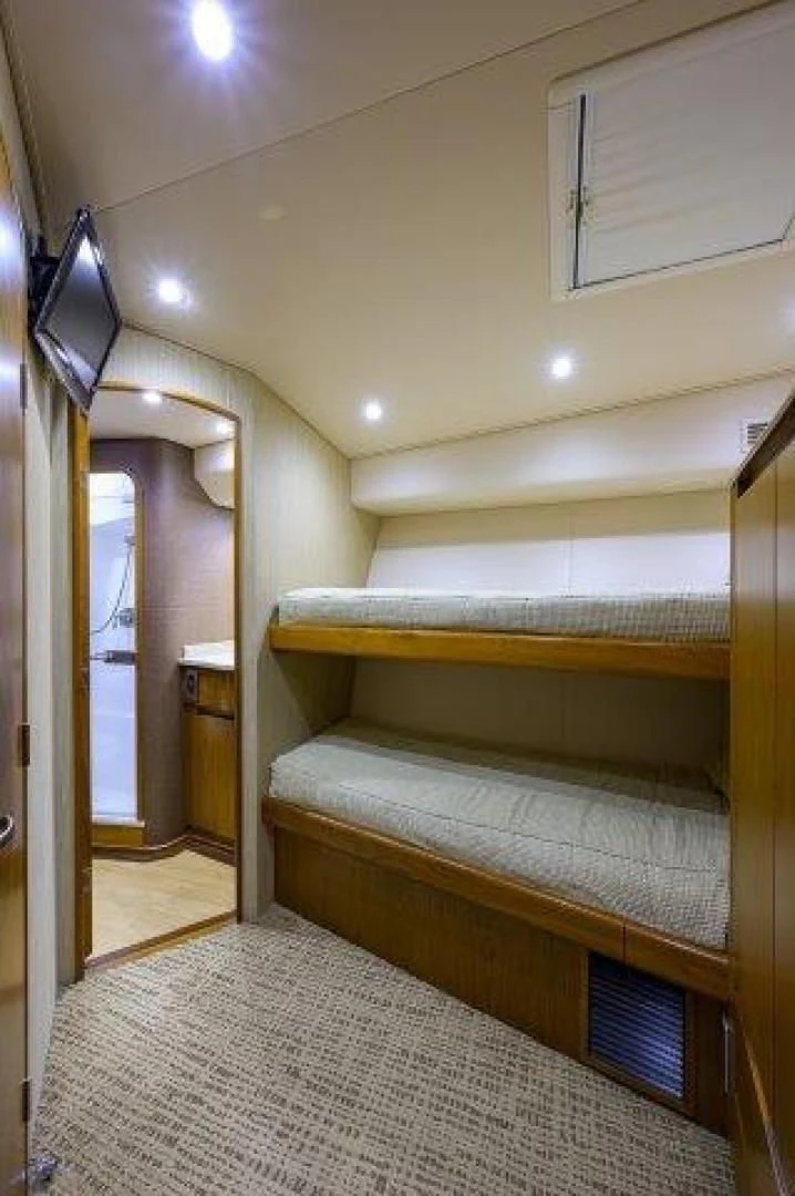 a room with a bed and a television on the wall aboard LITTLE AUDREY Yacht for Sale