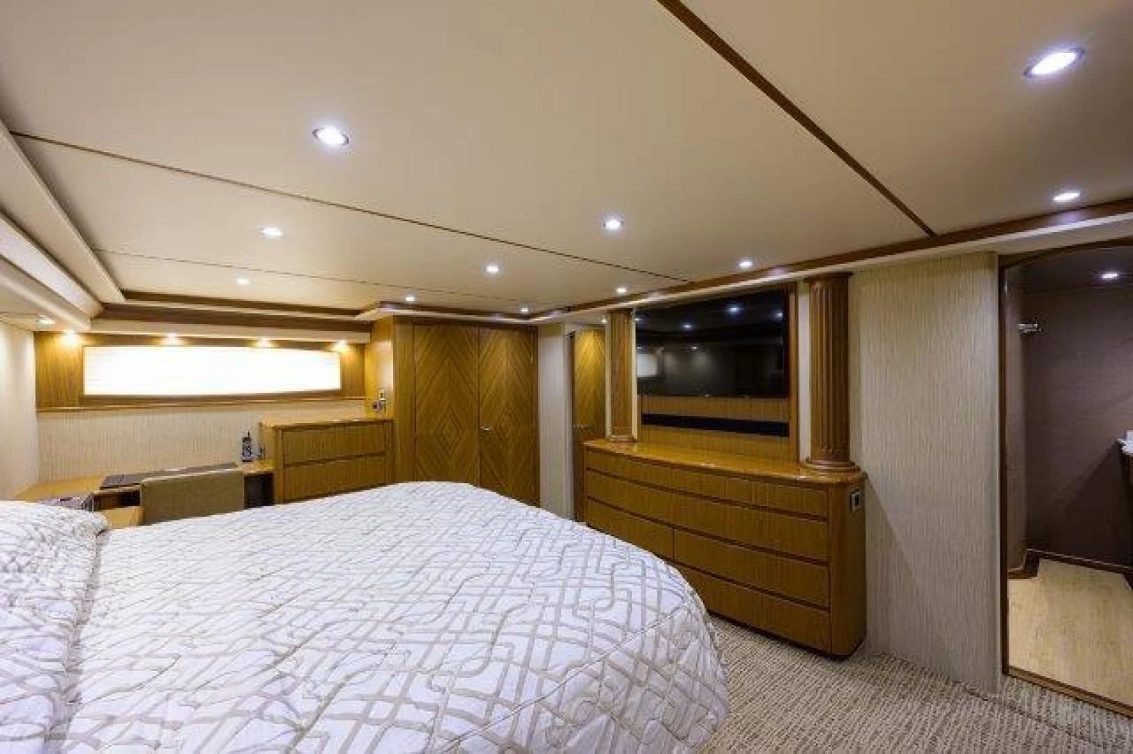 a bedroom with a bed and a wood cabinet aboard LITTLE AUDREY Yacht for Sale