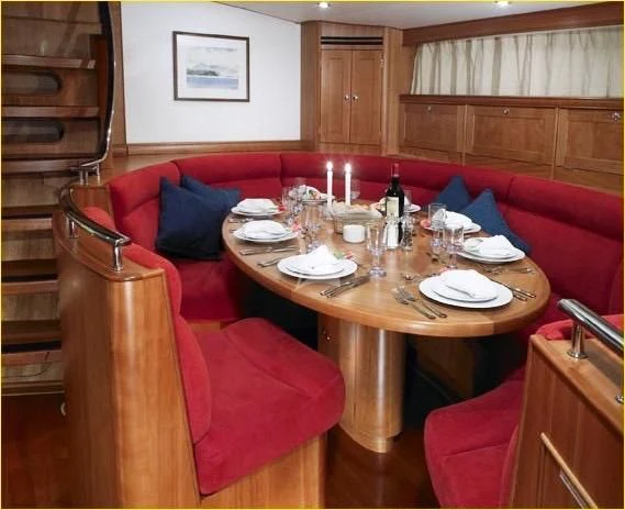 a dining table with plates and glasses aboard DARK STAR OF LONDON Yacht for Charter